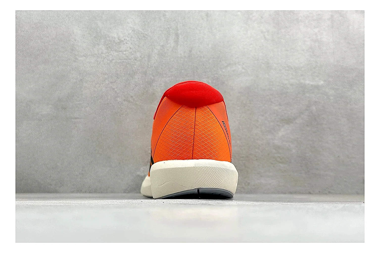Adidas Adizero Orange Black shopping brief photo showing orange runner upper, black three-stripe contrast, lightweight racing shape, and thin performance sole thumbnail 6
