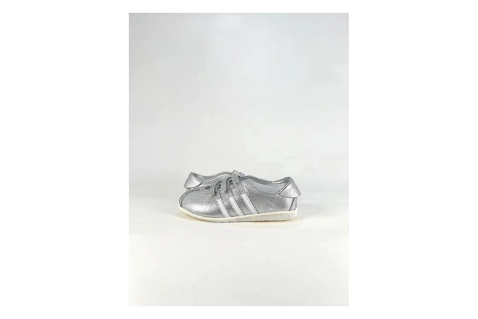 Adidas Originals Anfisa Silver Sneakers shopping brief image showing silver low-top sneakers with leather texture, side-profile shape, upper panel lines, and outsole detail