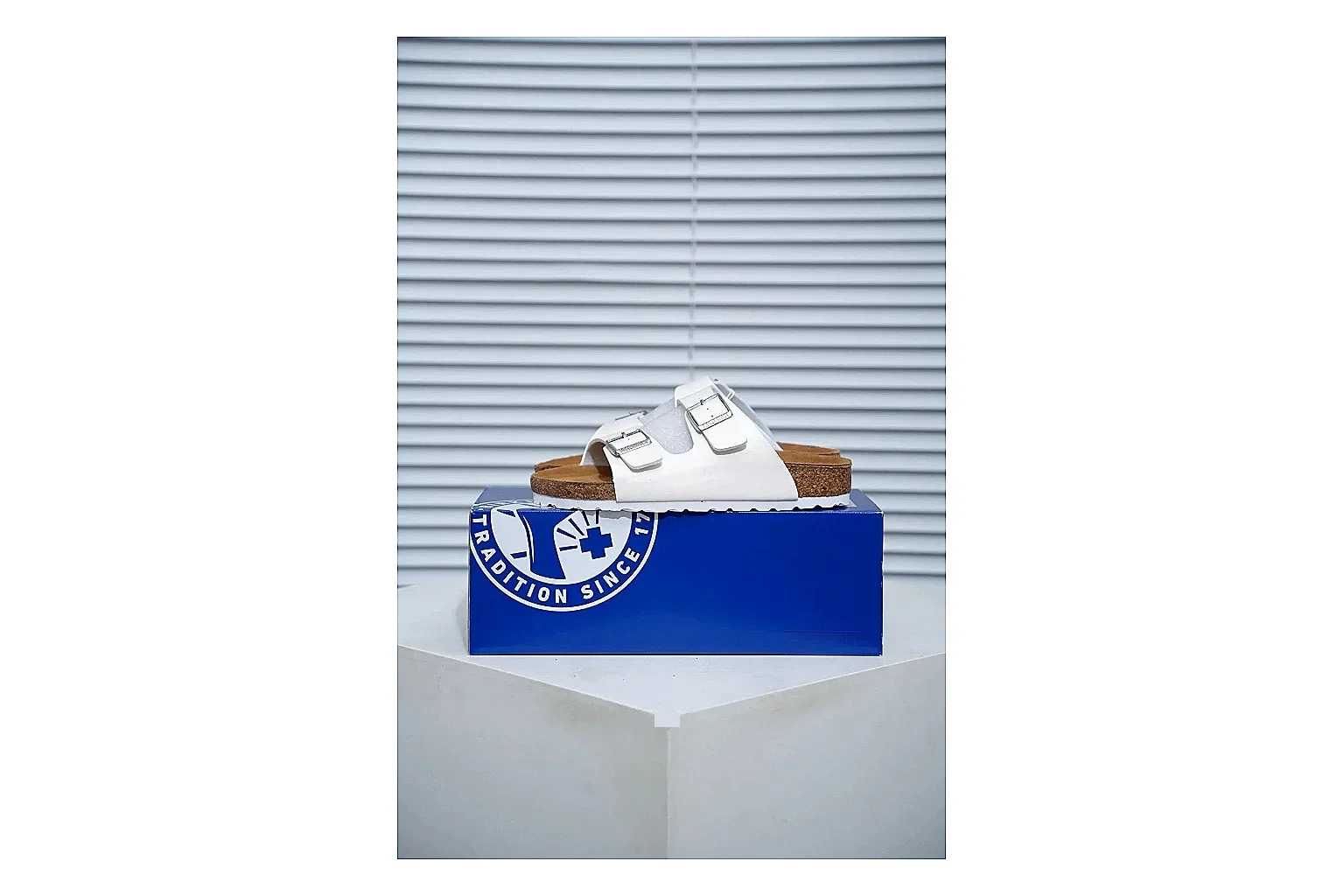 Birkenstock Arizona White Cork Slide shopping brief image showing adjustable buckles, contoured footbed and black outsole for clean summer casual styling