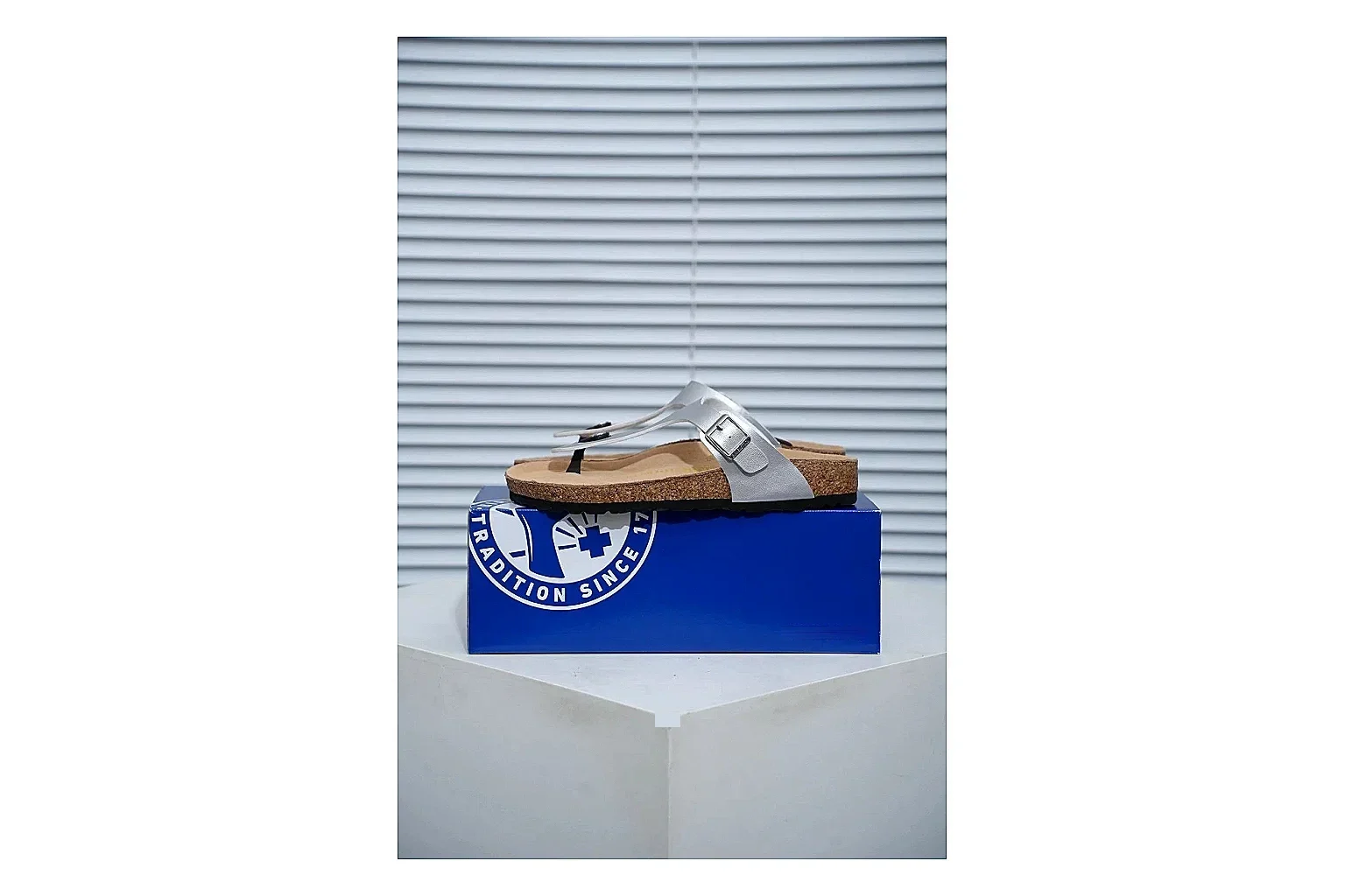 Birkenstock Cream Buckle Cork Slide shopping brief image showing wide strap, large metal buckle and contoured footbed for simple summer comfort