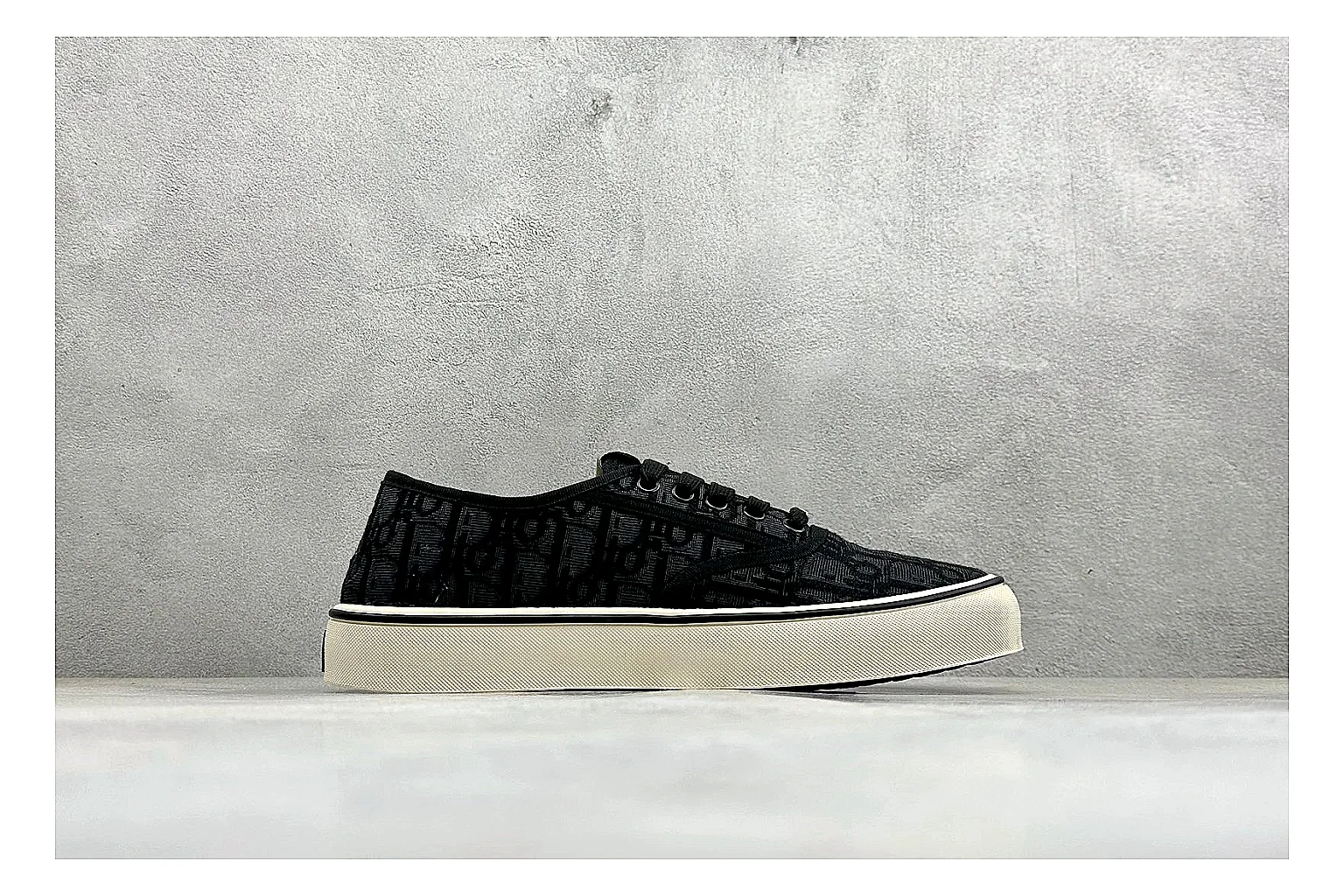 Dior Act Slide Black Low-Top shopping brief photo showing black monogram-style upper, low slip-on shape, chunky dark sole, and luxury casual profile thumbnail 4