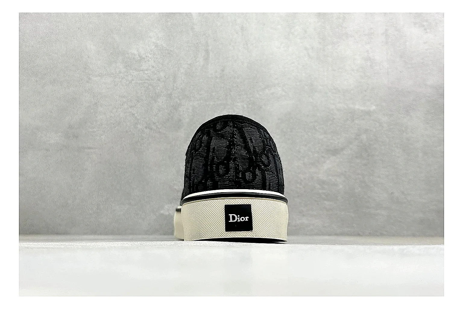 Dior Act Slide Black Low-Top shopping brief photo showing black monogram-style upper, low slip-on shape, chunky dark sole, and luxury casual profile thumbnail 6