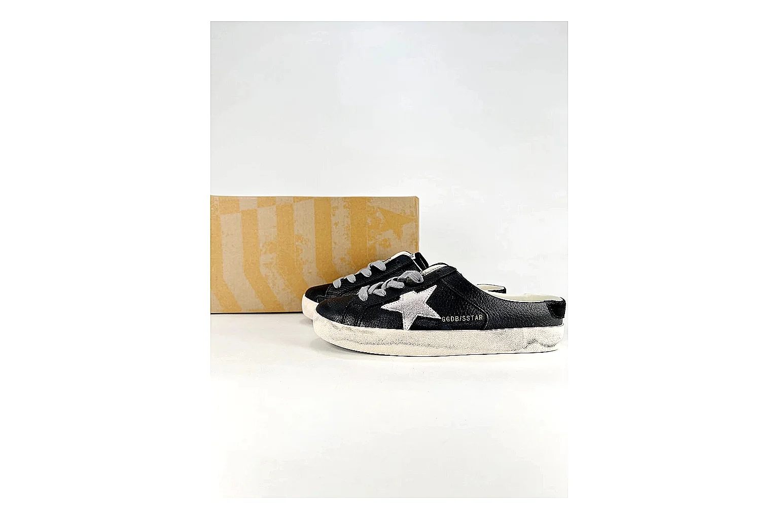 GGDB Super-Star Black White Sneakers shopping brief image showing black white distressed low-top sneakers with leather texture, side-profile shape, upper panel lines, and outsole detail