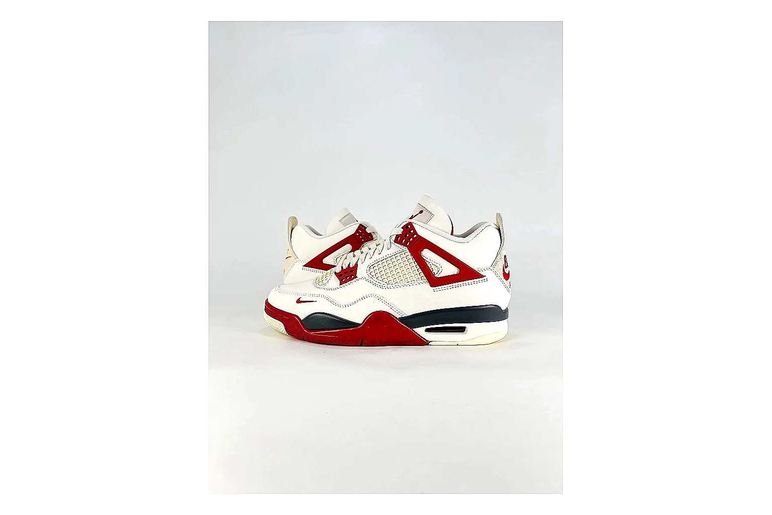 Jordan Air Jordan 4 White Red Sneakers shopping brief image showing white red retro basketball sneakers with leather texture, side-profile shape, upper panel lines, and outsole detail