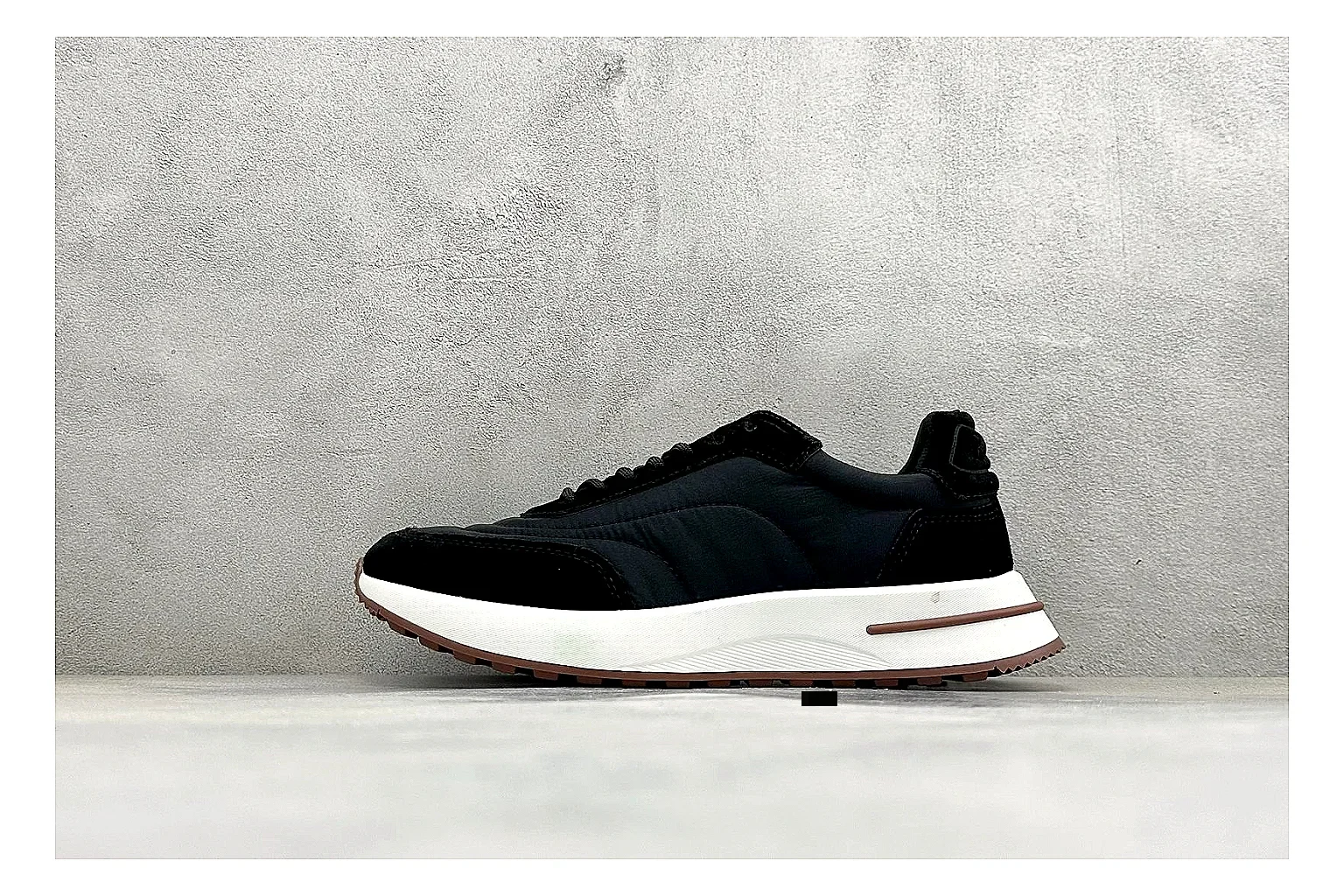 Loro Piana Week-End Black shopping brief image showing black suede upper, low casual profile, striped midsole accent, and soft everyday shape