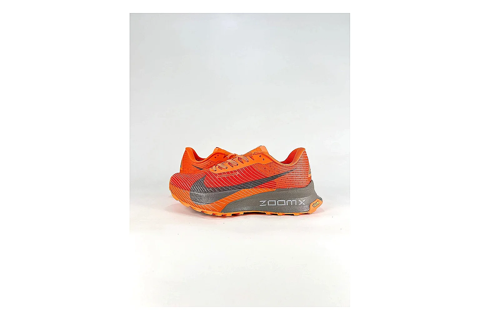 Nike ACG Ultra Orange Gray Sneakers shopping brief image showing orange gray outdoor sneakers with textile texture, side-profile shape, upper panel lines, and outsole detail