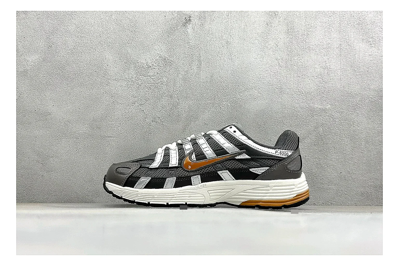 Nike P-6000 Black Orange shopping brief photo showing black layered runner upper, orange accent hits, retro P-6000 paneling, and cushioned casual sole