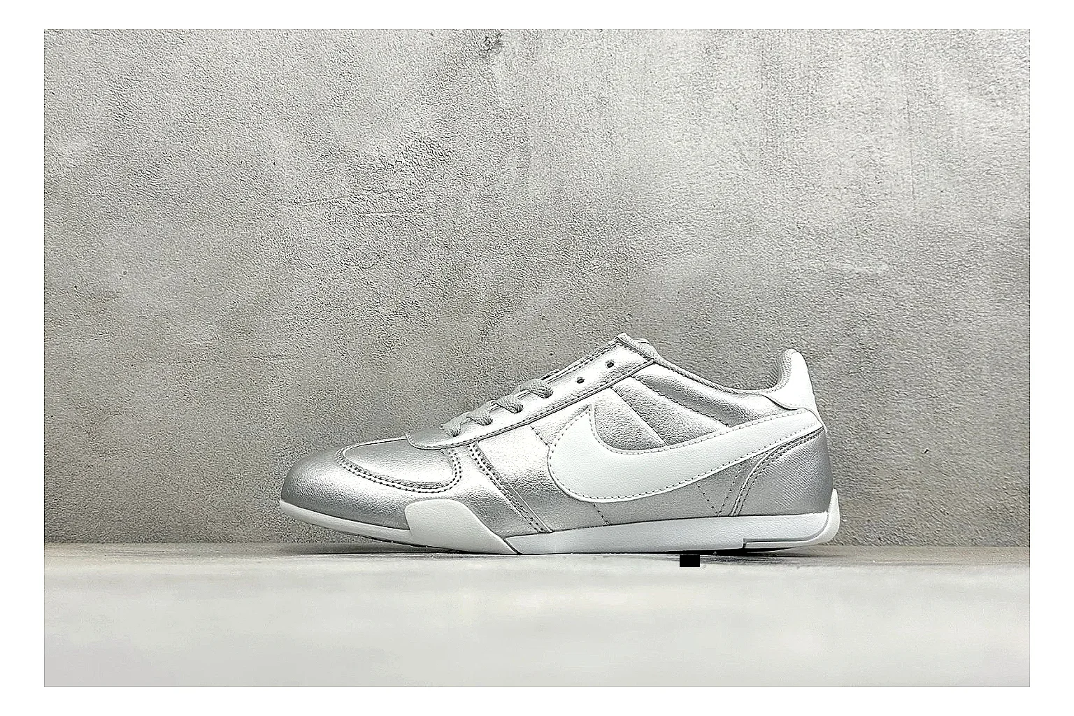 Nike Sprint Sister Silver shopping brief photo showing silver retro-runner upper, slim low-top shape, layered side panels, and a light everyday sole