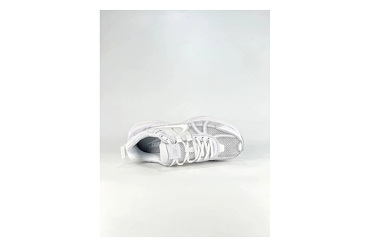 Nike V2K Run White Sneakers shopping brief image showing white retro runner sneakers with mesh-leather texture, side-profile shape, upper panel lines, and outsole detail thumbnail 5