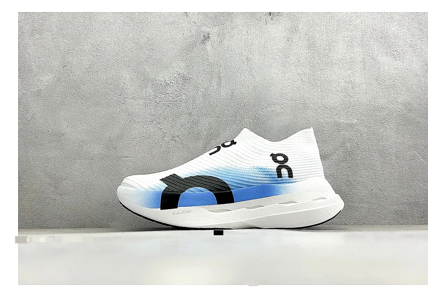 On Cloudboom White Blue shopping brief photo showing white performance mesh, blue gradient accents, slim racing profile, and segmented CloudTec sole
