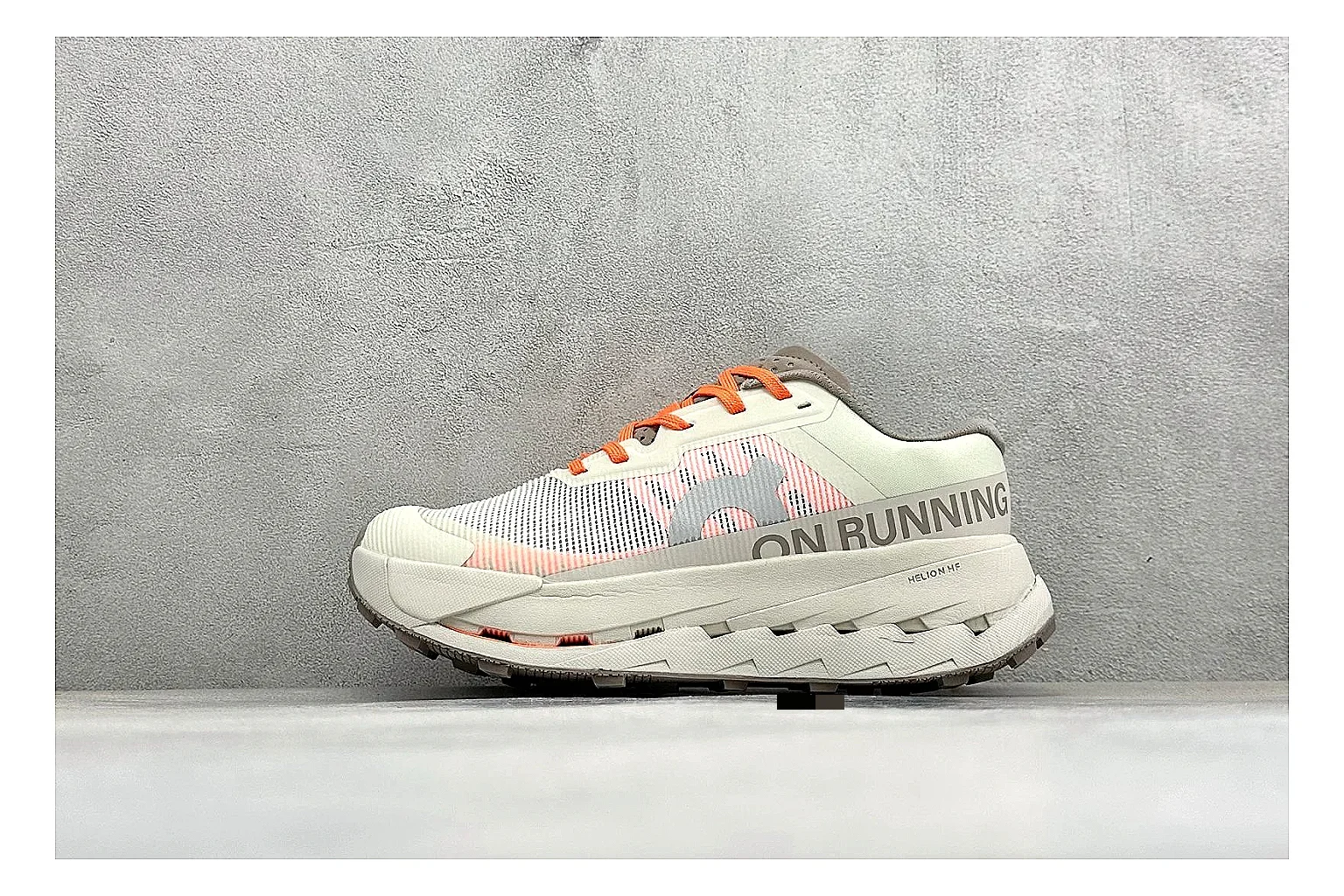 On Cloudmonster White Orange shopping brief photo showing white running mesh, orange accent hits, oversized CloudTec sole pods, and a rounded runner silhouette