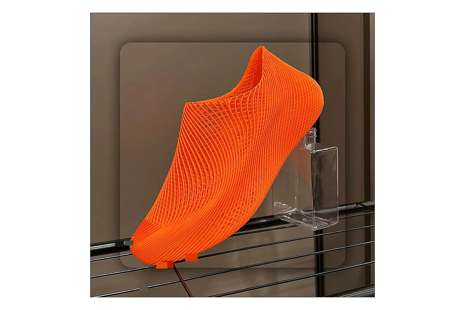 Other 4D Printed Orange Slip-On Sneakers shopping brief photo showing orange open-grid upper, seamless slip-on shape, sculpted sole, and futuristic lightweight profile