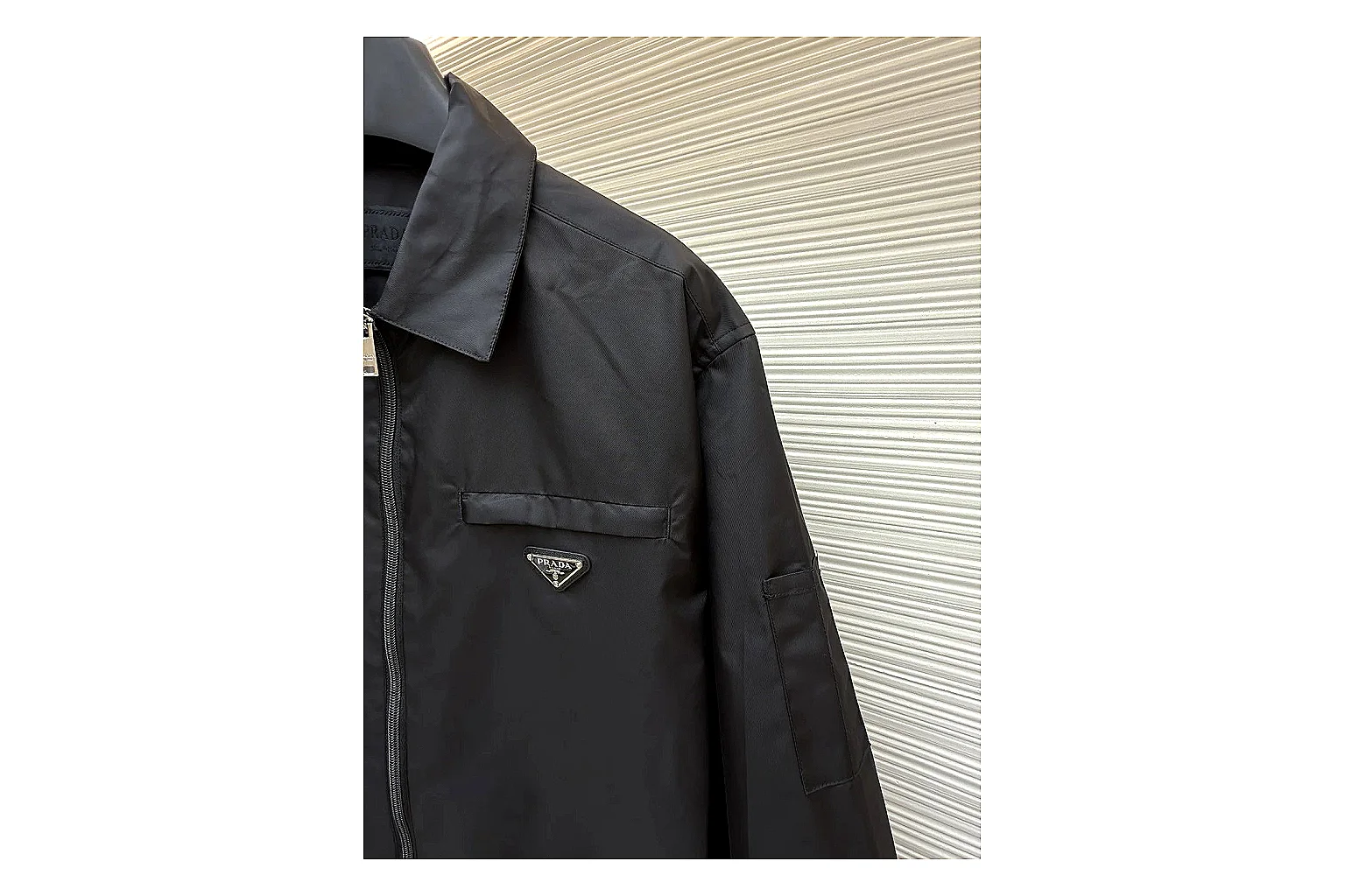 Prada Re-Nylon Hooded Jacket Black Jacket shopping brief image showing black Re-Nylon hooded jacket with recycled-nylon texture, hood structure, zipper line, sleeve cuffs, and light shell shape thumbnail 3