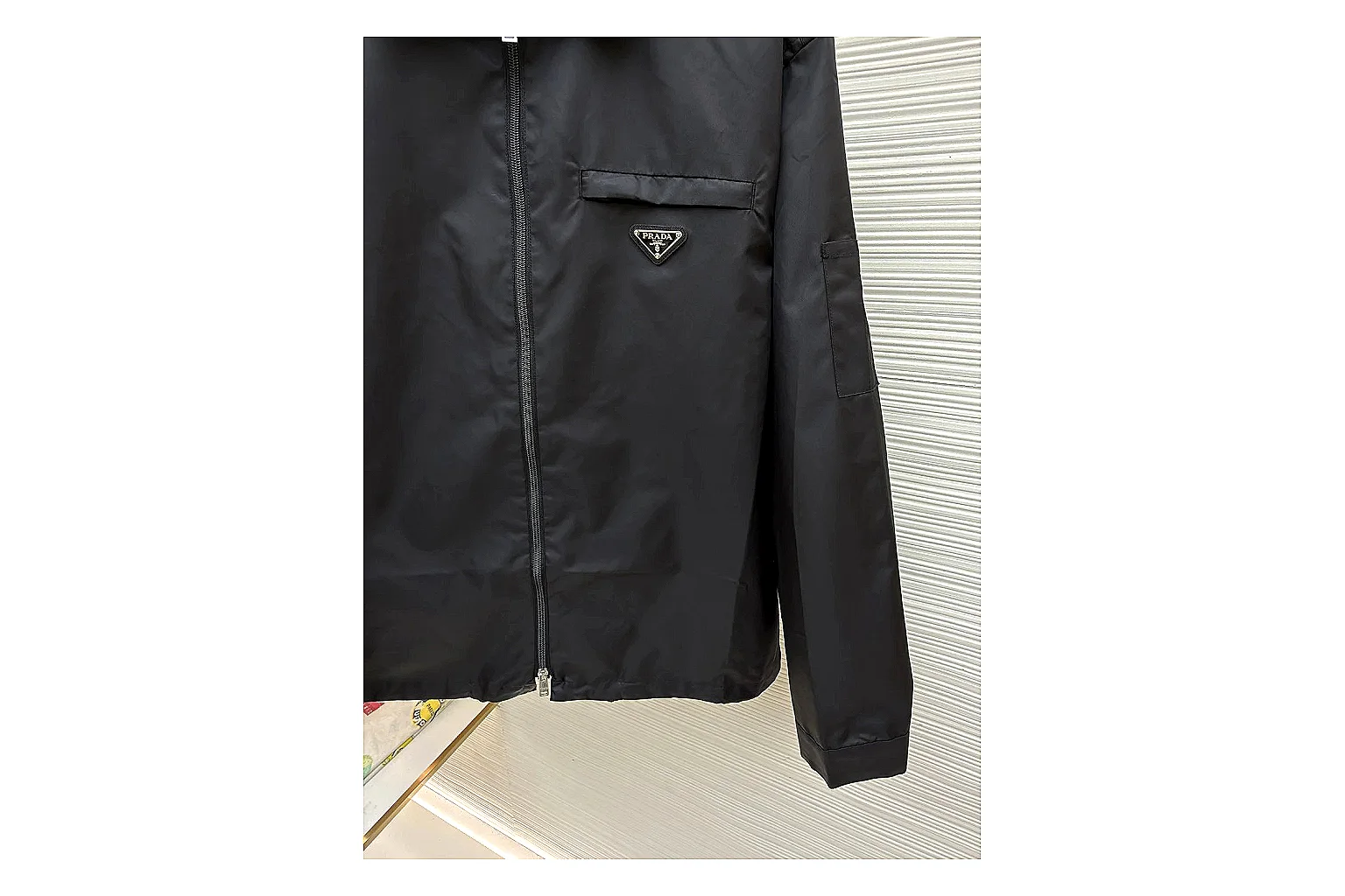 Prada Re-Nylon Hooded Jacket Black Jacket shopping brief image showing black Re-Nylon hooded jacket with recycled-nylon texture, hood structure, zipper line, sleeve cuffs, and light shell shape thumbnail 5